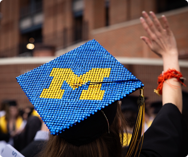 Maize and Blue Block M Bedazzled graduation cap at a graduation ceremony