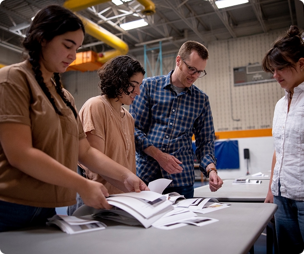 Faculty and students look through papers on a table